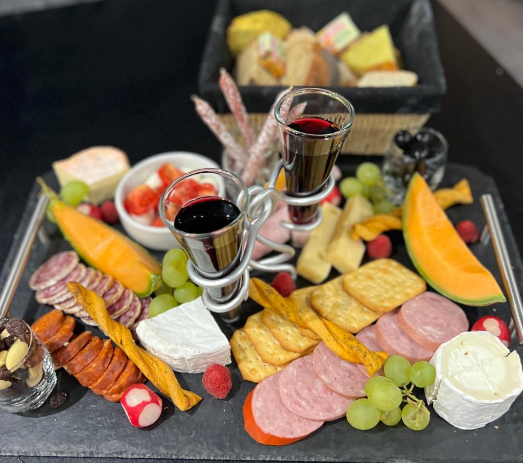 un plateau de nourriture avec deux verres de vin et des amuse-gueules dans l'établissement Dôme S'féérique avec accès piscine, à Saint-Évarzec