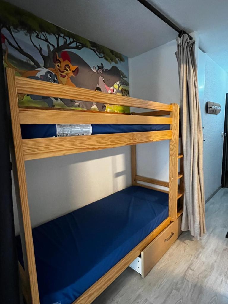 un lit superposé dans une chambre avec un lit inférieur bleu dans l'établissement Ski Piau engaly 50 m des pistes de ski et du cœur de station, à Aragnouet