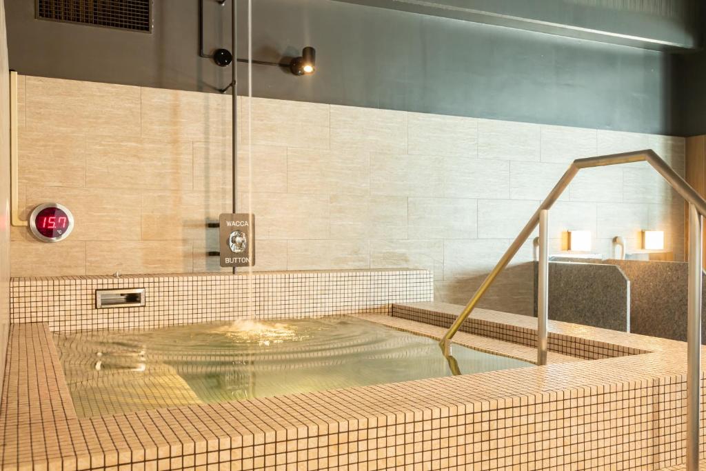 - une douche avec piscine d'eau dans la chambre dans l'établissement Kiki Shiretoko Natural Resort, à Shari
