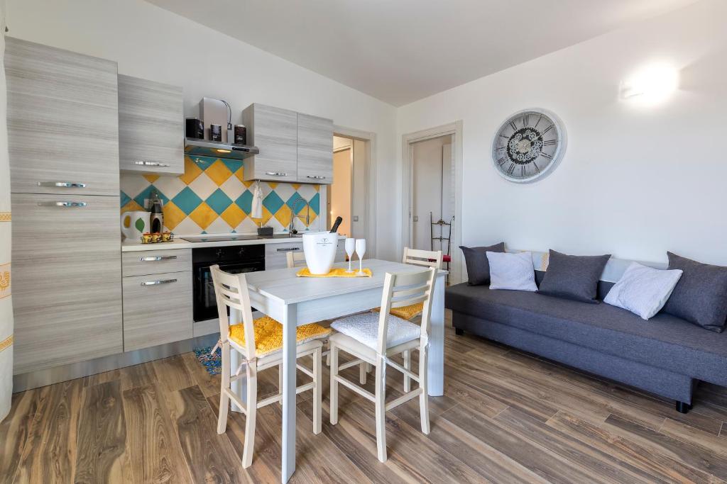 une cuisine et un salon avec une table et des chaises dans l'établissement Residenza alla Collina & Romantic SPA, à Porto Conte