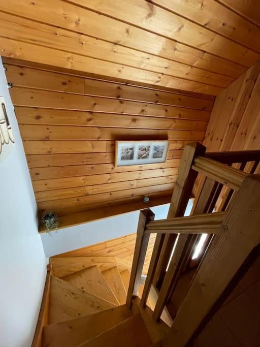 un escalier dans une cabane en bois avec une photo sur le mur dans l'établissement Duplex dans chalet au coeur de la station, à Réallon