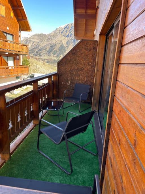 - deux chaises sur un balcon avec vue sur la montagne dans l'établissement Duplex dans chalet au coeur de la station, à Réallon