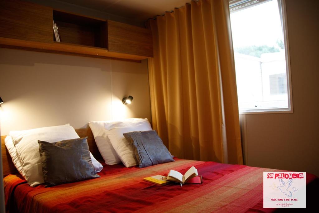 - une chambre avec un lit et un livre dans l'établissement Mobil Home-Sa Palomera- Camping Mar Estang-Canet en Roussillon 66140, à Canet 10 autres photos