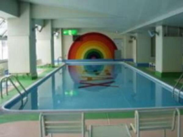 une piscine avec un arc-en-ciel au milieu dans l'établissement Hotel Spax Kusatsu, à Kusatsu