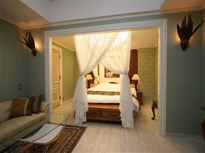 une chambre avec un lit, un canapé et un miroir dans l'établissement 本庄バニラリゾート, à Ishigami