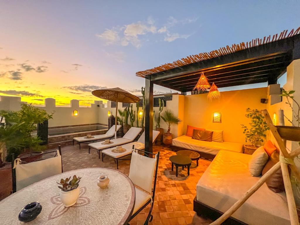 - un toit-terrasse avec un canapé, des tables et des chaises dans l'établissement Riad des Lys, à Marrakech
