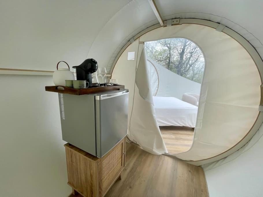- un miroir rond dans une chambre avec un lit dans l'établissement Fun'ambulle, à Féneyrols