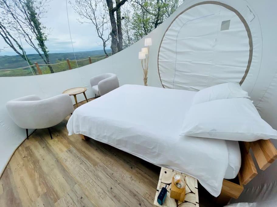 - une chambre avec un lit et un miroir rond dans l'établissement Fun'ambulle, à Féneyrols 6 autres photos
