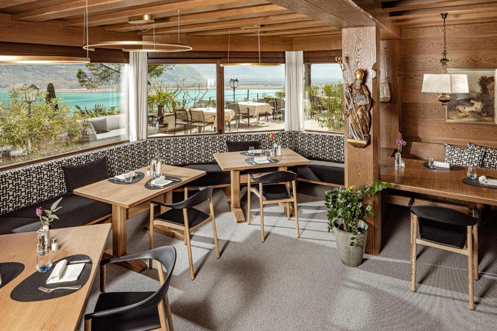 un restaurant avec des tables et des chaises en bois et des fenêtres dans l'établissement Hotel Haus am Hang, à Caldaro