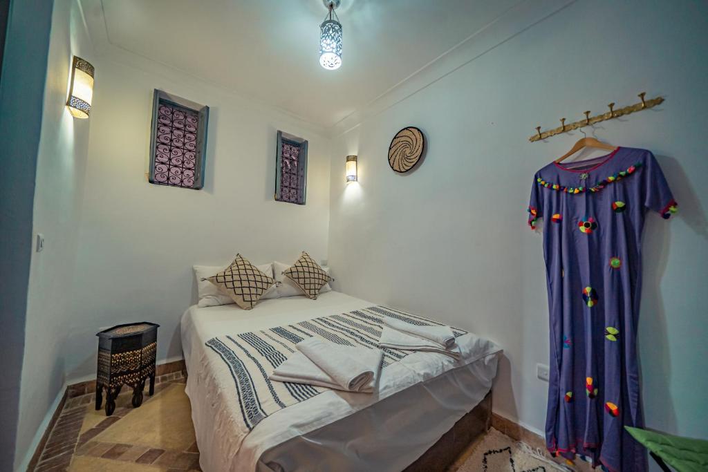 - une chambre avec un lit et un rideau sur le mur dans l'établissement Riad Azawan, à Marrakech 37 autres photos