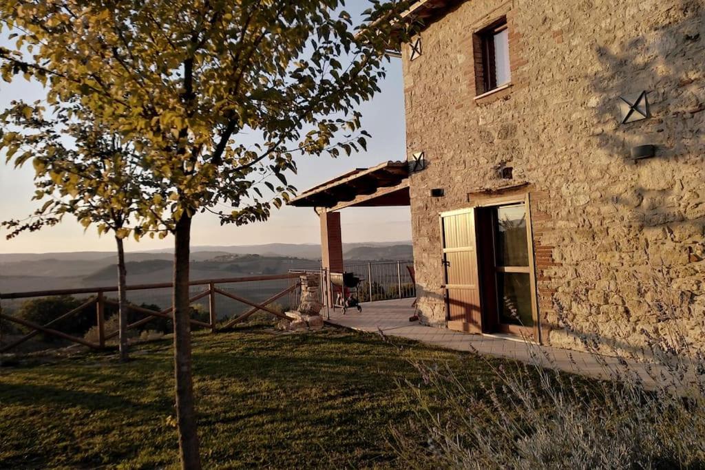 un bâtiment avec un arbre devant lui dans l'établissement Casale dei 3 galli, à Configni