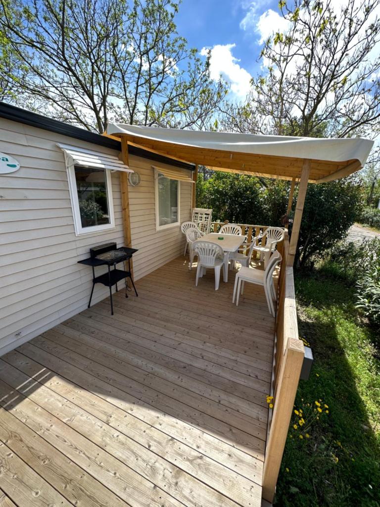 une terrasse avec une table, des chaises et un parasol dans l'établissement Au p’tit bonheur, à La Roque-dʼAnthéron 3 autres photos