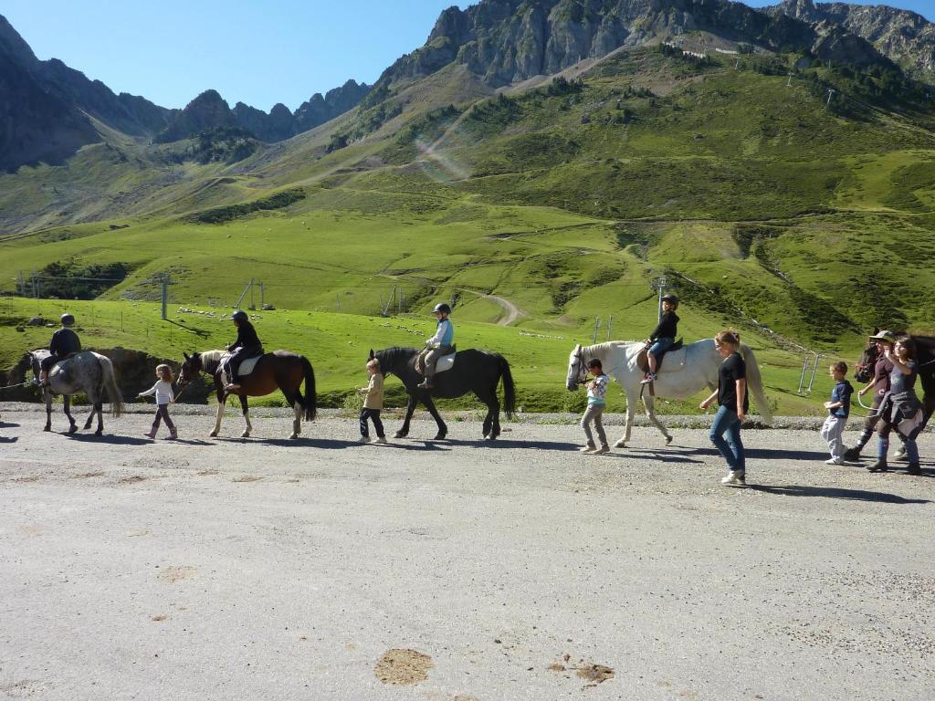 un groupe de personnes à cheval sur un chemin de terre dans l'établissement Résidence Mer & Golf Tourmalet, à La Mongie