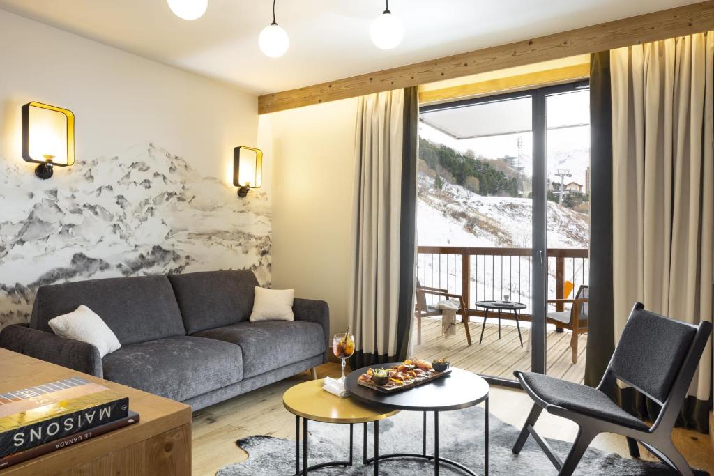 un salon avec un canapé et une table dans l'établissement HIGALIK HOTEL, aux Menuires
