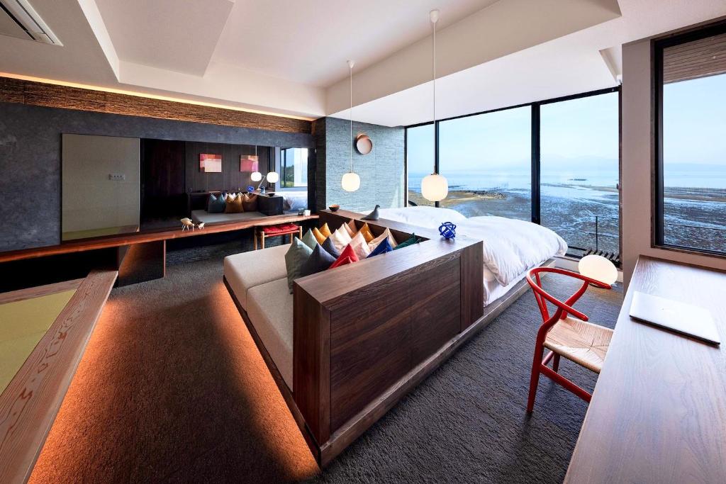 une chambre avec un lit, un bureau et un canapé dans l'établissement Tara Dakeonsen Kanigoten, à Tara