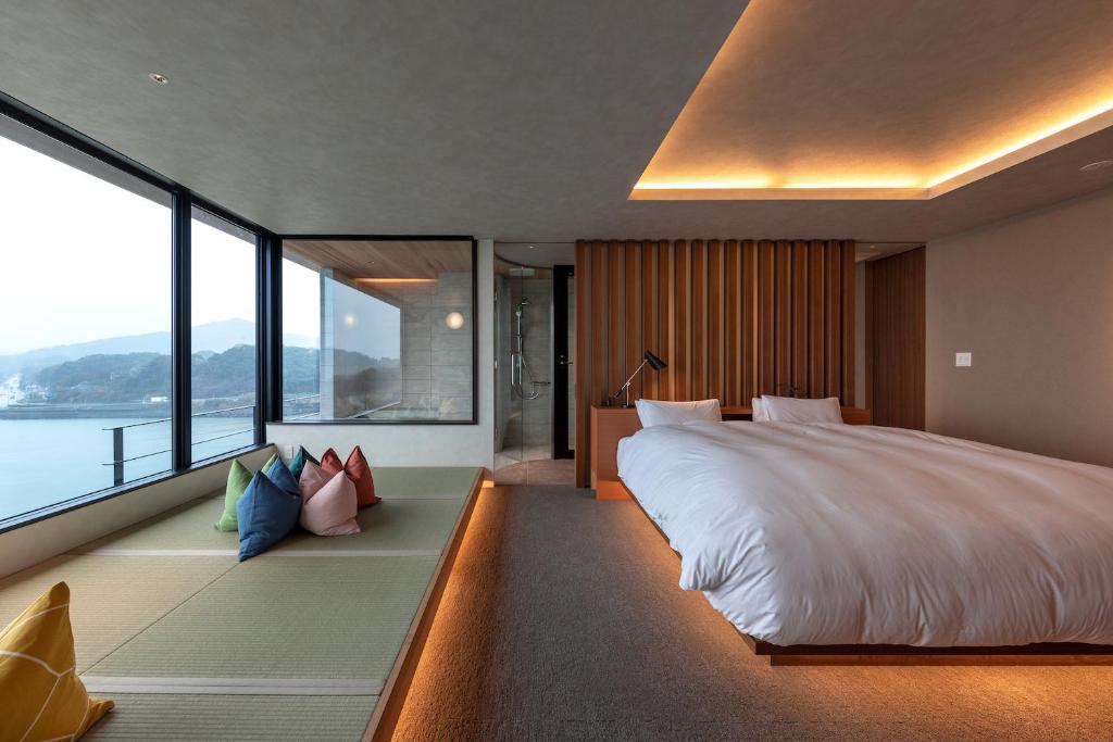 une chambre avec un grand lit et une grande fenêtre dans l'établissement Tara Dakeonsen Kanigoten, à Tara 180 autres photos