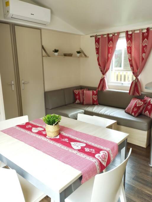 un salon avec une table et un canapé dans l'établissement Mobil-home tout confort climatisé 6 personnes proche Europa Park, route des vins, Alsace, à Boofzheim
