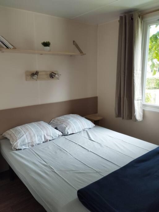 un grand lit dans une chambre avec une fenêtre dans l'établissement Mobil-home tout confort climatisé 6 personnes proche Europa Park, route des vins, Alsace, à Boofzheim