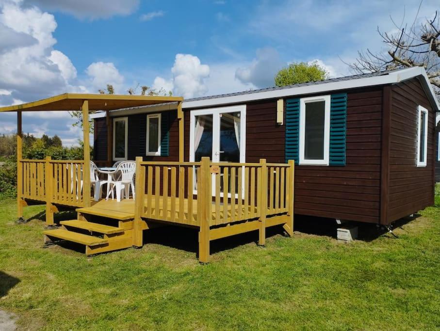 une petite maison avec un porche et une terrasse dans l'établissement Mobil-home tout confort climatisé 6 personnes proche Europa Park, route des vins, Alsace, à Boofzheim 2 autres photos