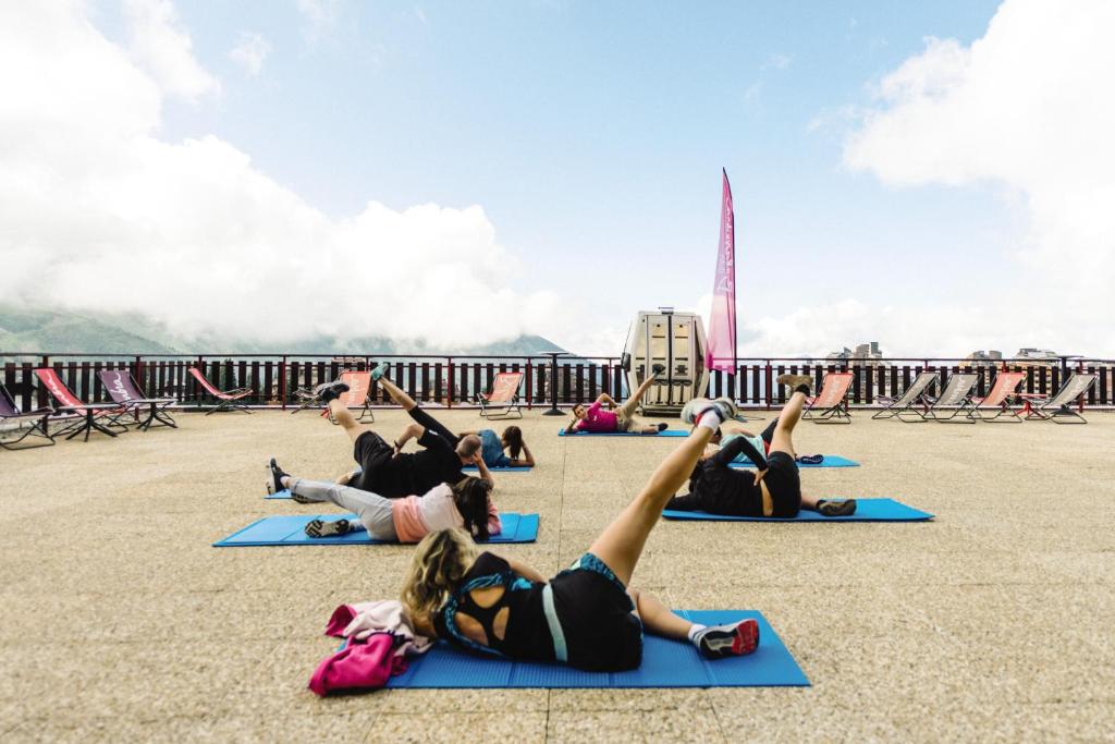 un groupe de personnes faisant du yoga sur la jetée dans l'établissement Belambra Clubs Avoriaz - Les Cimes du Soleil, à Avoriaz