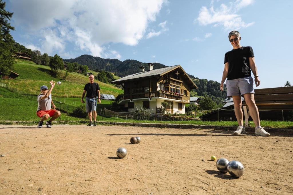 un groupe de personnes jouant avec des balles sur un terrain en terre battue dans l'établissement Belambra Clubs Praz-sur-Arly - L'Alisier, à Praz-sur-Arly