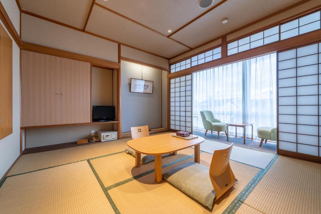 une pièce avec une table et des chaises dans une pièce dans l'établissement Ryokan Ryokufuso, à Kyoto