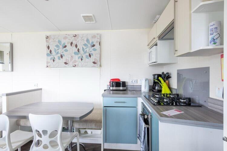 une cuisine avec un comptoir et une table avec des chaises dans l'établissement Mobilhome familial de luxe 3 chambres, à Onzain