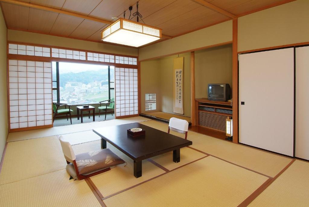 un salon avec une table et des chaises et une fenêtre dans l'établissement Takahan, à Yuzawa