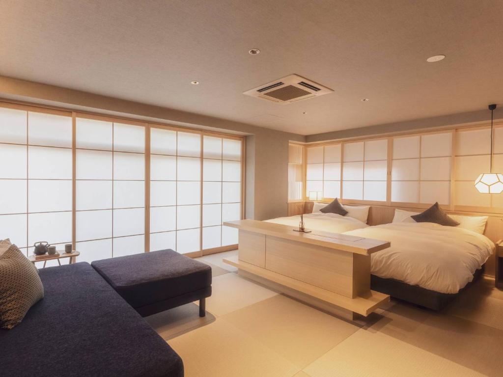 - une chambre avec un lit, un bureau et un canapé dans l'établissement Ryokan Asukasou at the entrancne of Nara park, à Nara