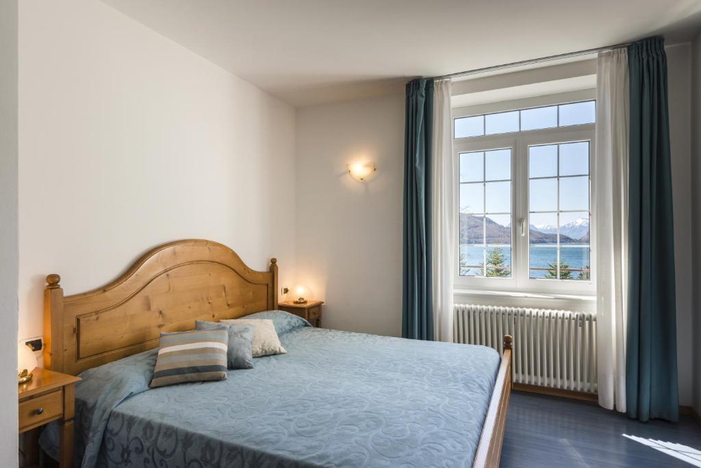 une chambre avec un lit et une grande fenêtre dans l'établissement Grand Hotel Molveno, à Molveno