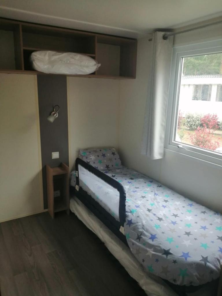 une petite chambre avec un lit et une fenêtre dans l'établissement Mobil Home St Jean De Monts A166, à Saint-Jean-de-Monts 15 autres photos