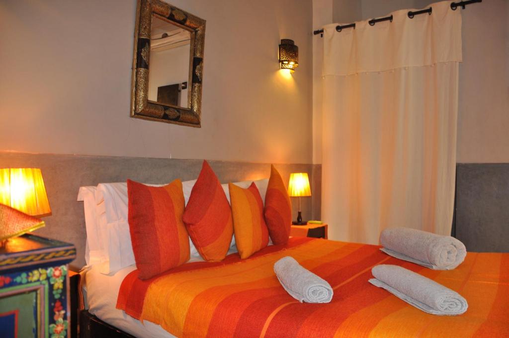 - une chambre dotée d'un grand lit avec des oreillers orange et orange dans l'établissement Riad des Etoiles, à Marrakech 37 autres photos