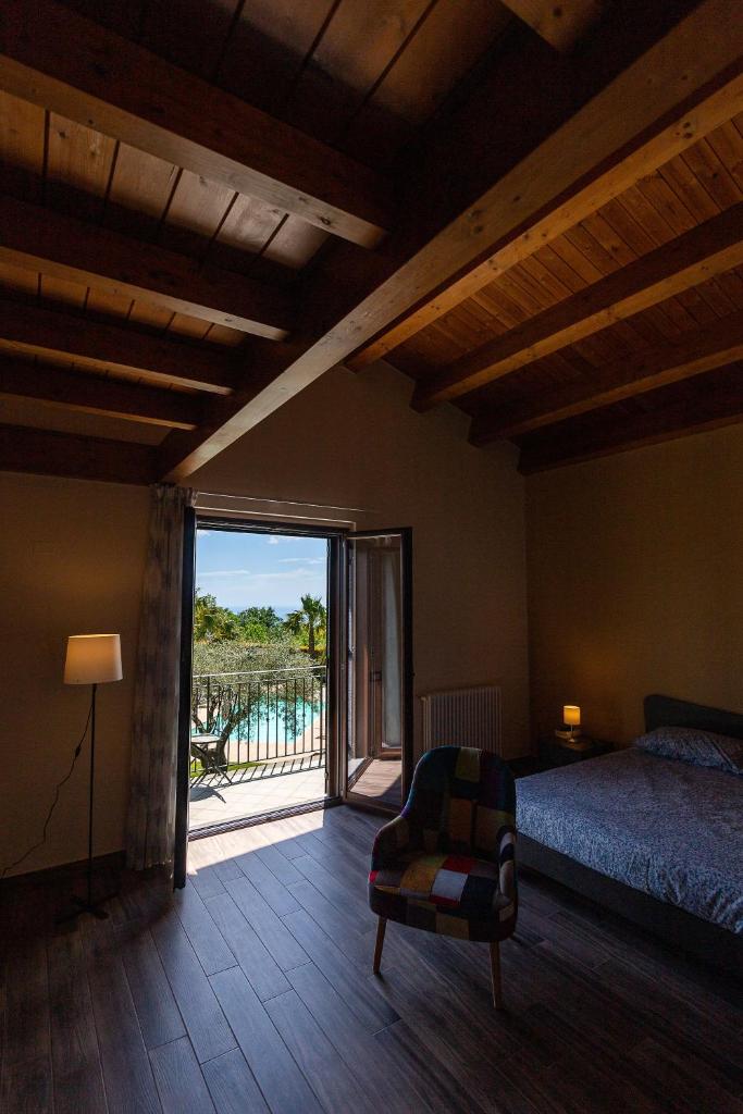 une chambre avec un lit et une vue sur une piscine dans l'établissement Casa Il Geranio, à Piedimonte Etneo