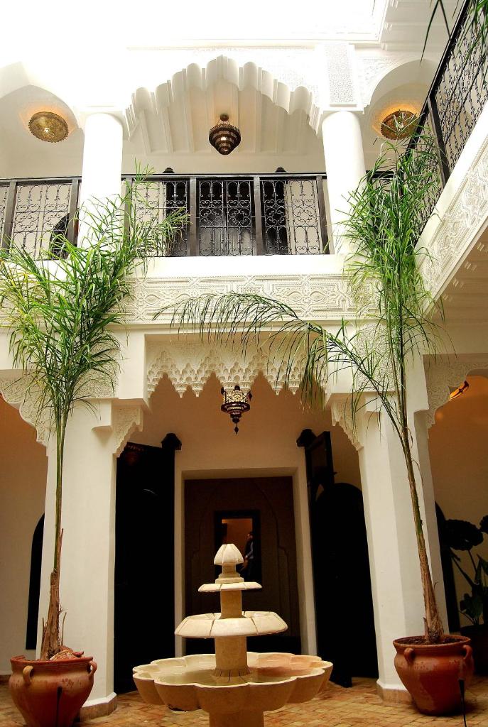 un hall d'entrée avec une fontaine au milieu d'un bâtiment dans l'établissement Hotel Riad Todos, à Marrakech