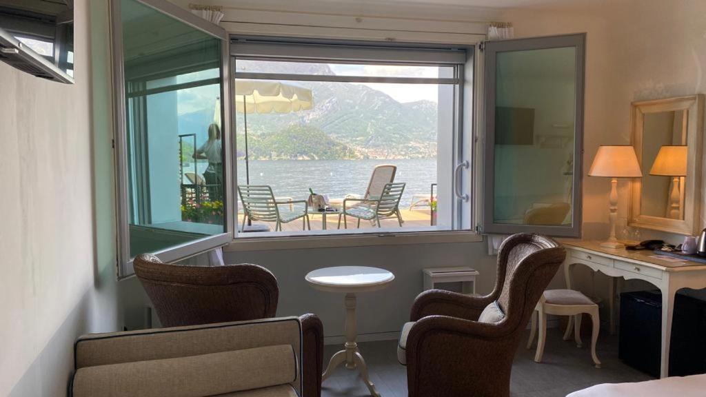 Cette chambre comprend une fenêtre avec des chaises et un bureau. dans l'établissement Hotel Villa Aurora, à Lezzeno