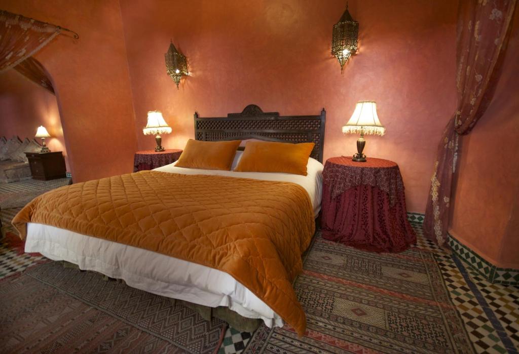 une chambre avec un grand lit et deux lampes dans l'établissement Dar Anebar, à Fès