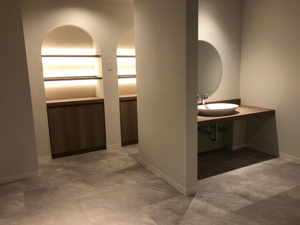 une salle de bain avec un lavabo et un miroir dans l'établissement Ureshino Onsen Yusyuku Sarayama, à Ureshino