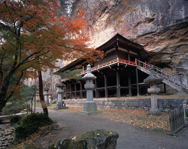 un bâtiment en face d'une montagne dans l'établissement Shizukatei, à Hiraizumi