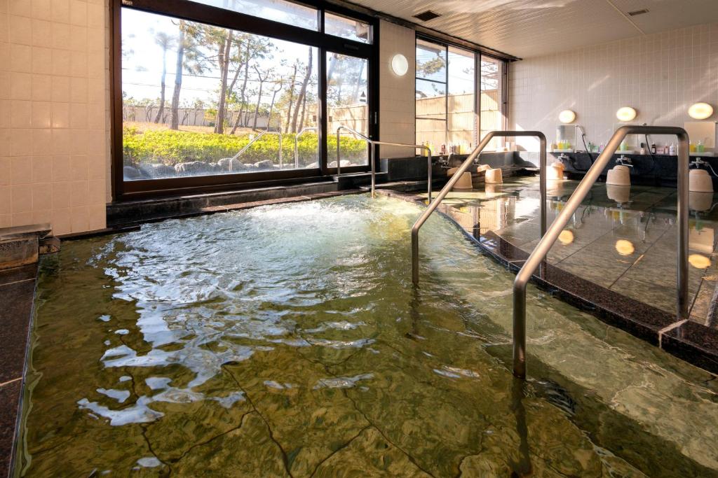 - une grande piscine d'eau dans une chambre avec fenêtres dans l'établissement KKR Numazu Hamayu, à Numazu 17 autres photos