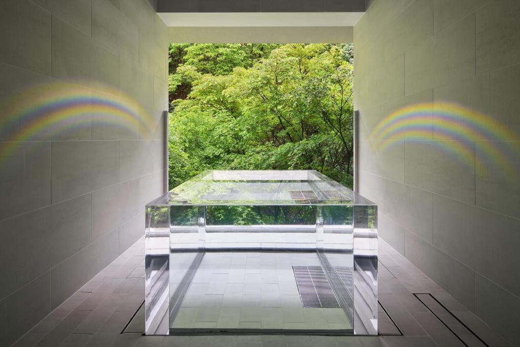 une table en verre dans une pièce à l'arc-en-ciel sur le mur dans l'établissement Ryokan Sumiya Kihoan, à Kameoka