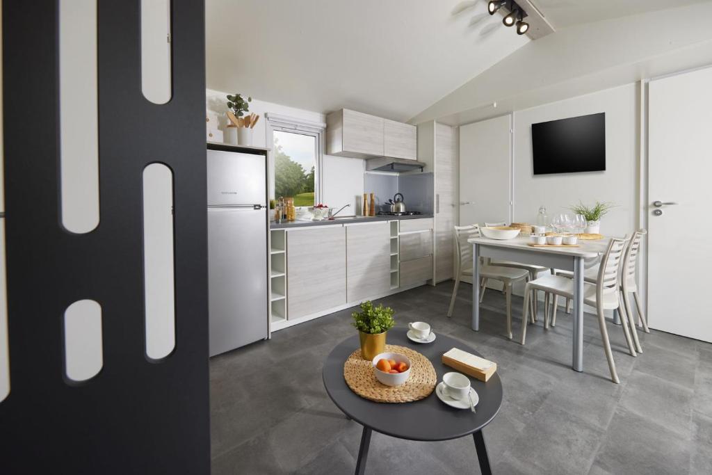 une cuisine avec une table et une salle à manger dans l'établissement West Camping, à Perros-Guirec