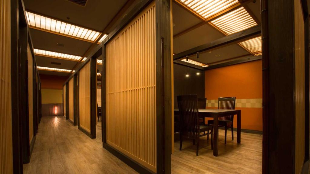 - un couloir avec une table et des chaises dans la chambre dans l'établissement Fujiya, à Kaga