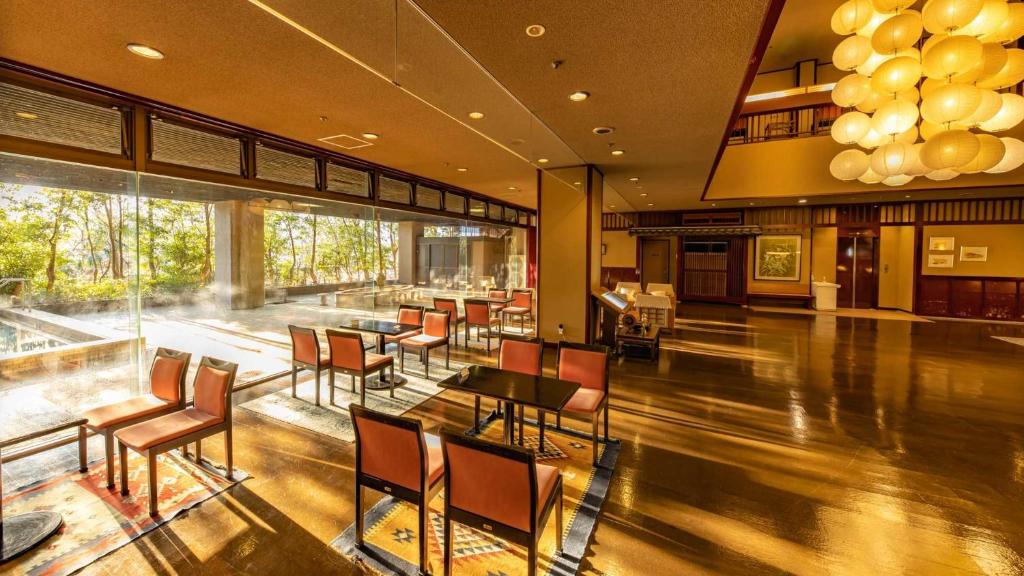 un restaurant avec des chaises et des tables dans un bâtiment dans l'établissement Fujiya, à Kaga