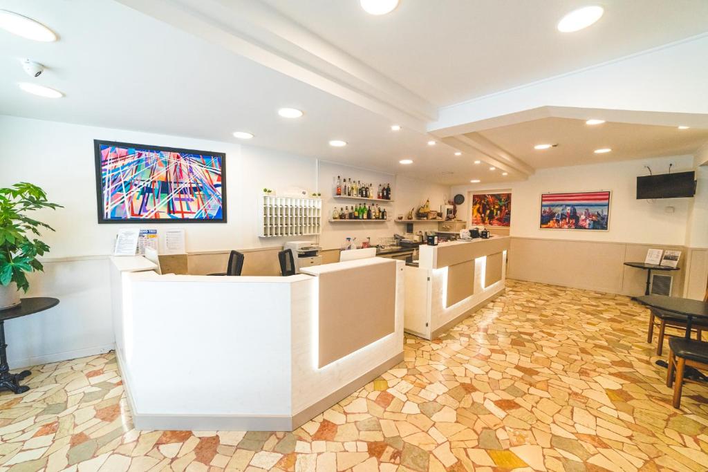 une salle d'attente avec un comptoir et une table dans l'établissement Hotel Grand Prix, à Sottomarina