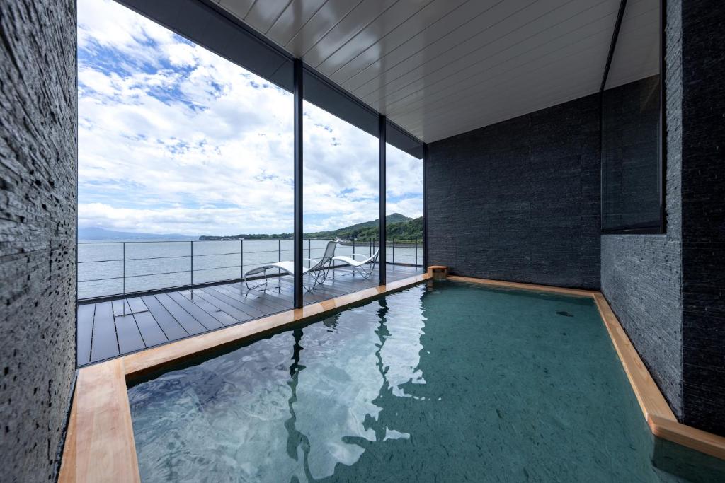 - une piscine dans une maison avec vue sur l'océan dans l'établissement Tara Dakeonsen Kanigoten, à Tara
