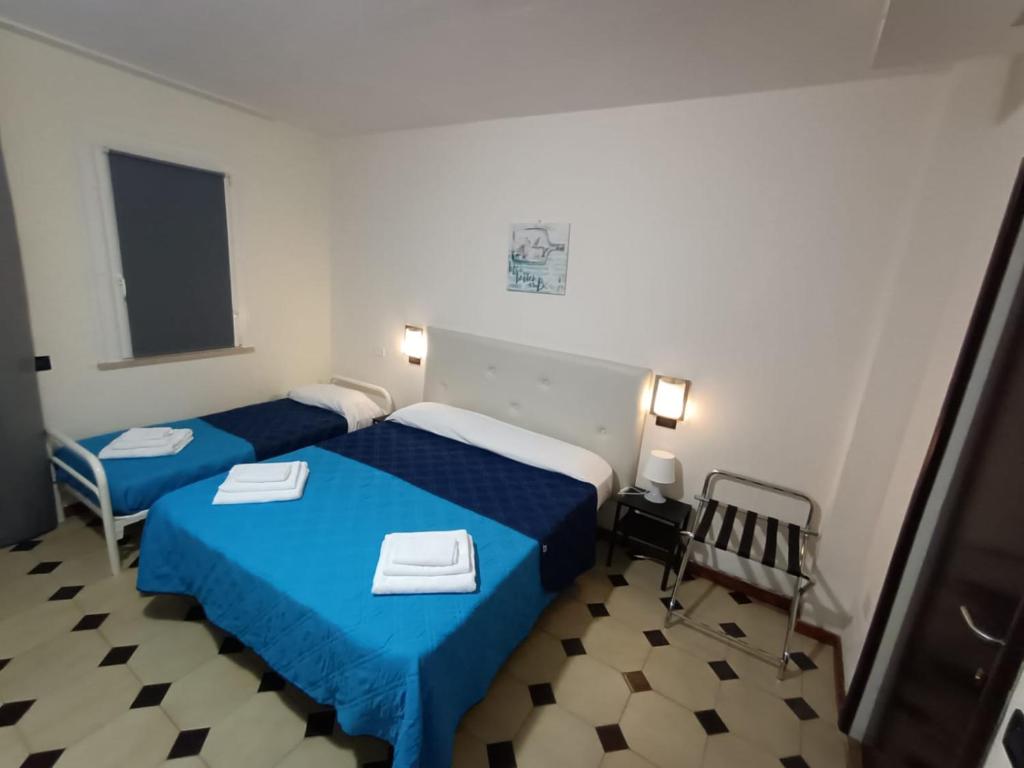 une chambre avec deux lits et une chaise dedans dans l'établissement Hotel La Torre, à Cervia