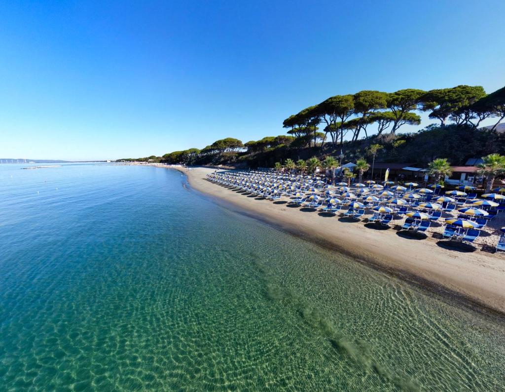 une plage déserte avec des chaises longues et l'océan dans l'établissement Hotel Giardino, à Follonica