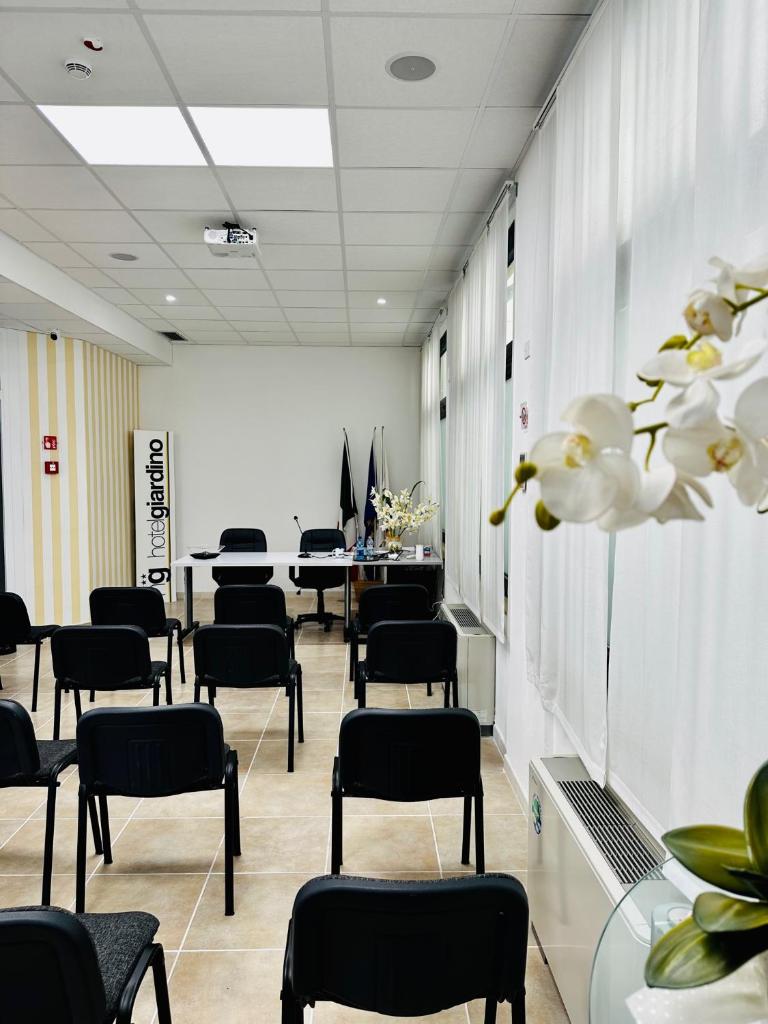 une salle d'attente avec des chaises, des tables et des fleurs dans l'établissement Hotel Giardino, à Follonica