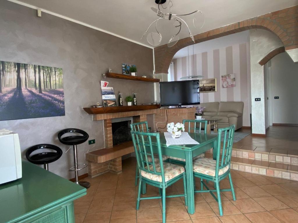 Il dispose d'une cuisine et d'un salon avec une table et des chaises vertes. dans l'établissement La Dolce Vita - Private Villa with Pool, à Moniga del Garda