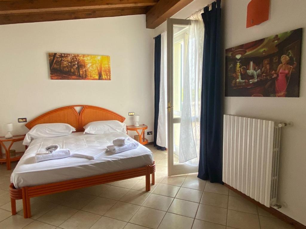 une chambre avec un lit avec des draps blancs et une fenêtre dans l'établissement La Dolce Vita - Private Villa with Pool, à Moniga del Garda